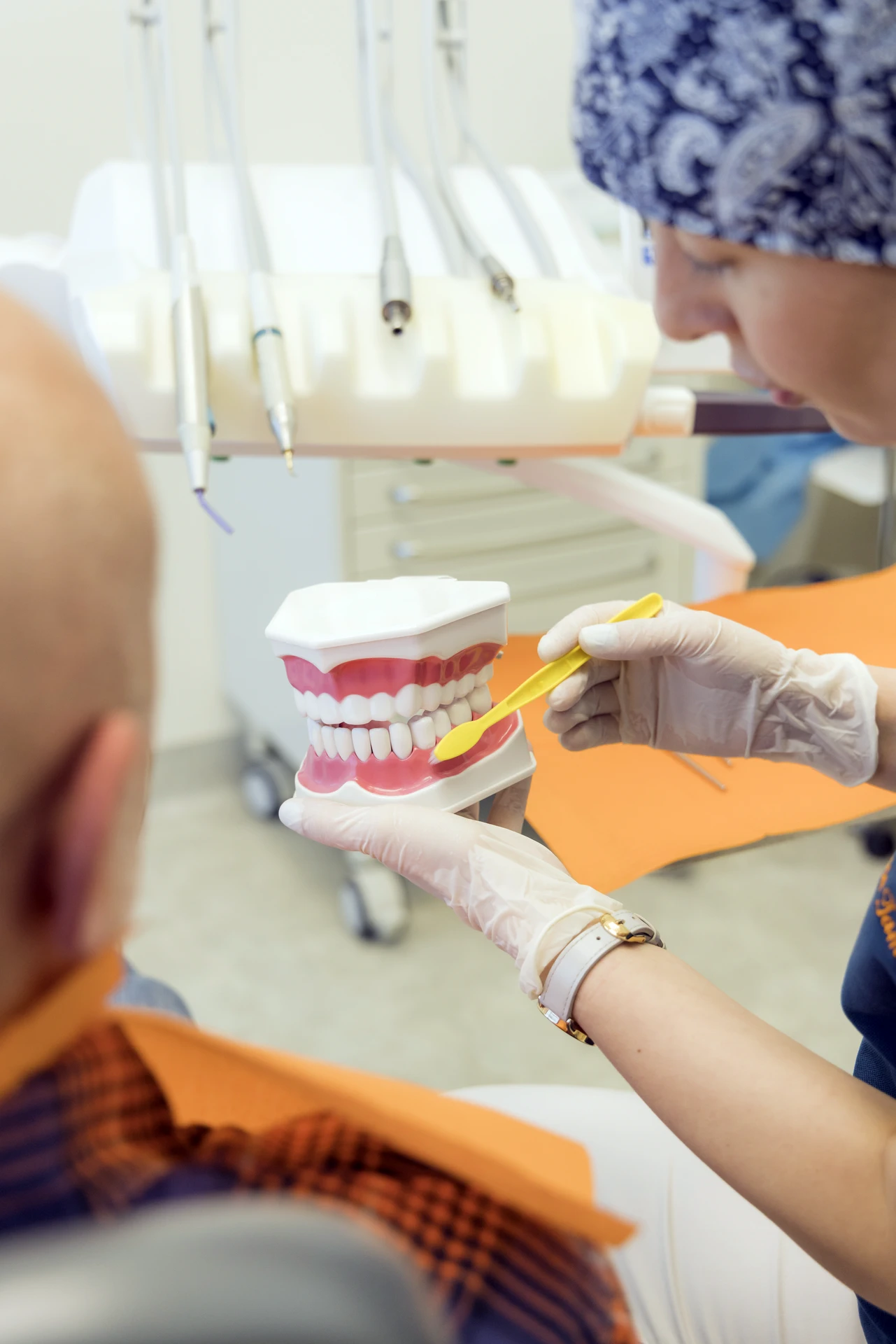 Igienista dentale del Centro Redolfi mostra le corrette tecniche di spazzolamento su un modello anatomico durante una seduta di igiene orale professionale.